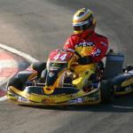 man wearing a racing uniform driving a go kart